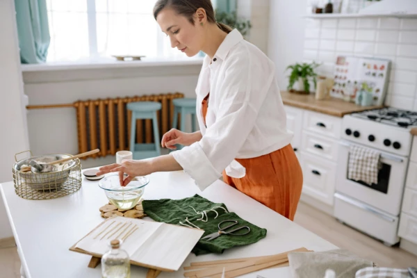 Woman Making Scented Candles on her Kitchen Table